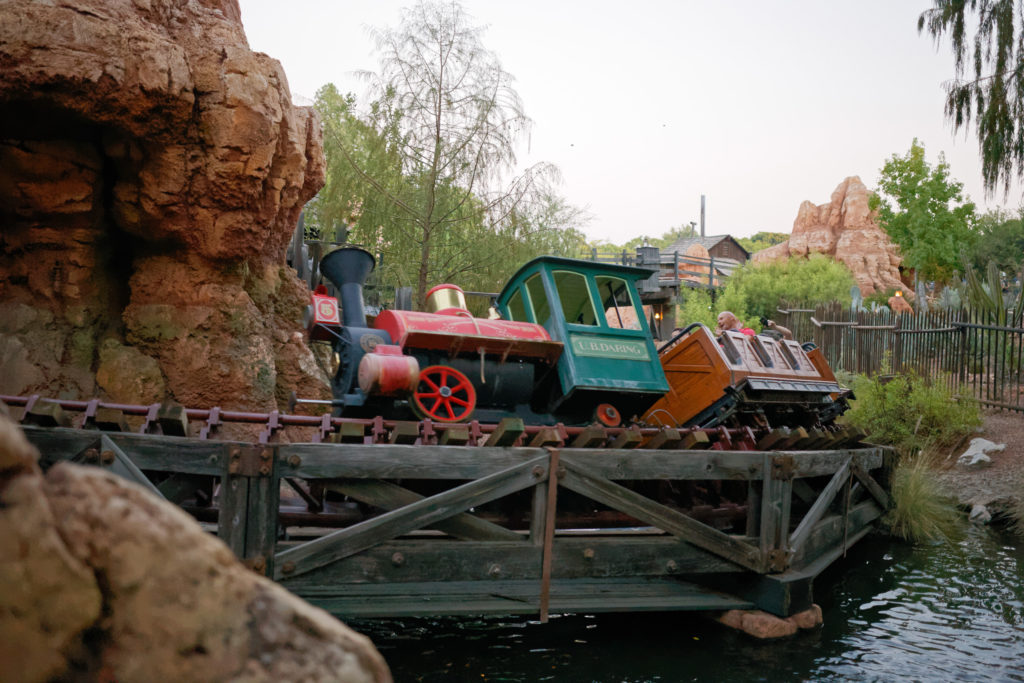 A Big Thunder Mountain Railway train passing over a trestle bridge in Disneyland.